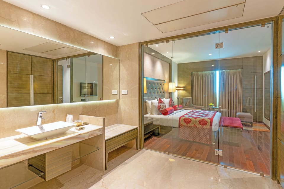 Suite, 1 King Bed | Bathroom | Combined shower/tub, rainfall showerhead, designer toiletries
