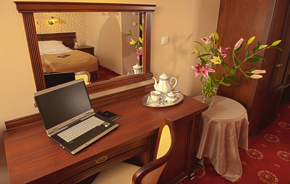 Hypo-allergenic bedding, desk, laptop workspace, blackout drapes