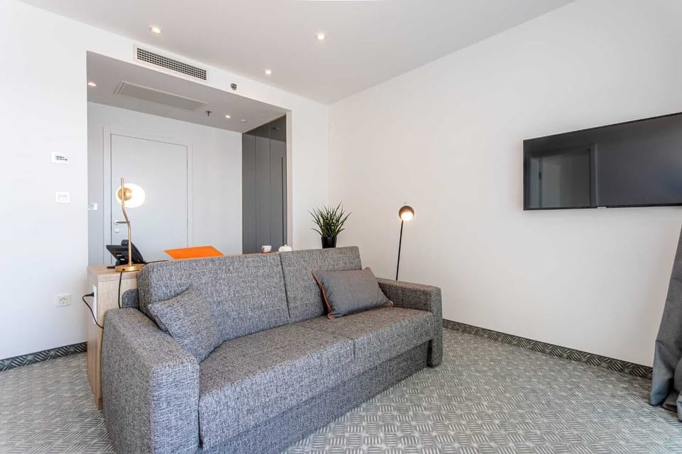 Deluxe Suite with balcony and sea view | Living area | 80-cm LCD TV with satellite channels, TV
