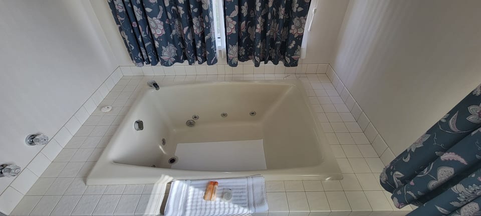 Deluxe Room, 1 Queen Bed, Jetted Tub | Bathroom | Combined shower/tub, free toiletries, hair dryer, towels