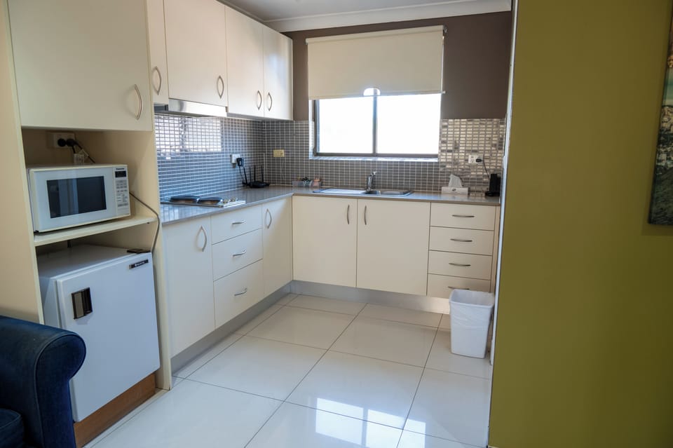 Deluxe Studio Suite, 1 King Bed, Kitchenette | Desk, laptop workspace, blackout drapes, iron/ironing board