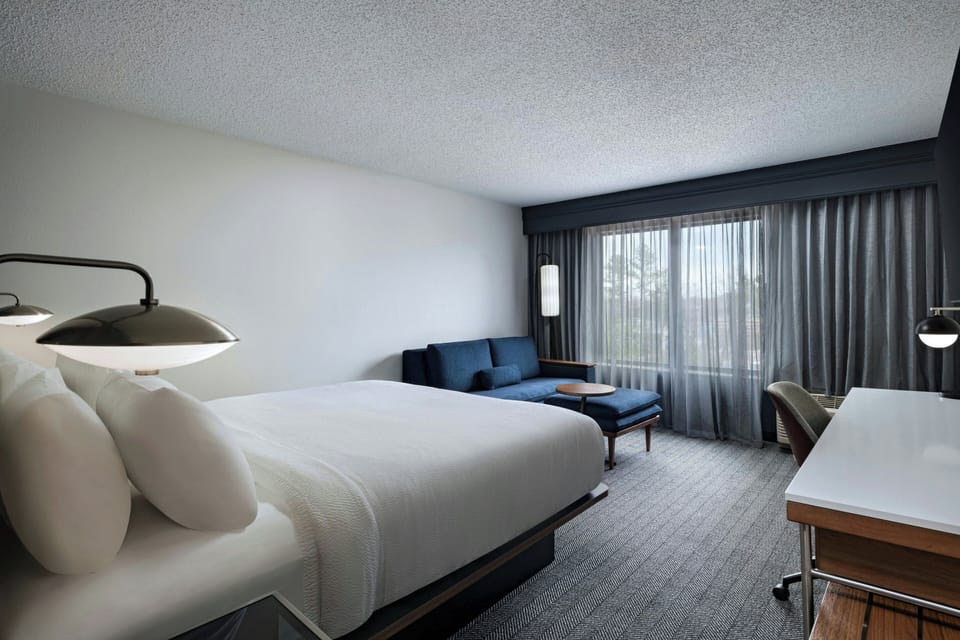 Premium bedding, desk, laptop workspace, blackout drapes