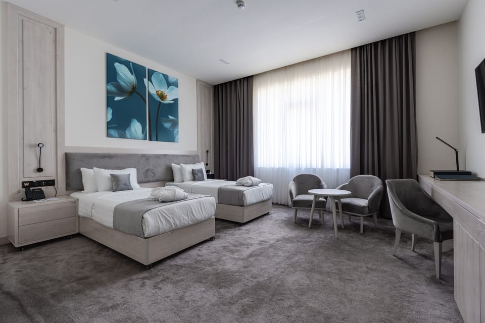 Deluxe Room | Minibar, in-room safe, laptop workspace, blackout drapes