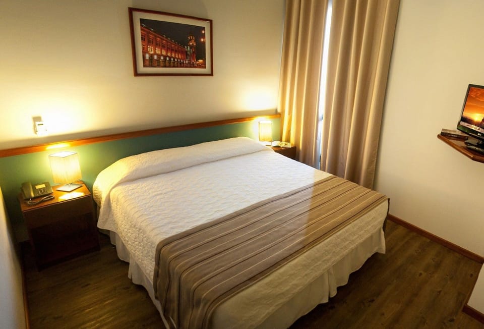 Apartamento Casal | Minibar, in-room safe, desk, blackout drapes