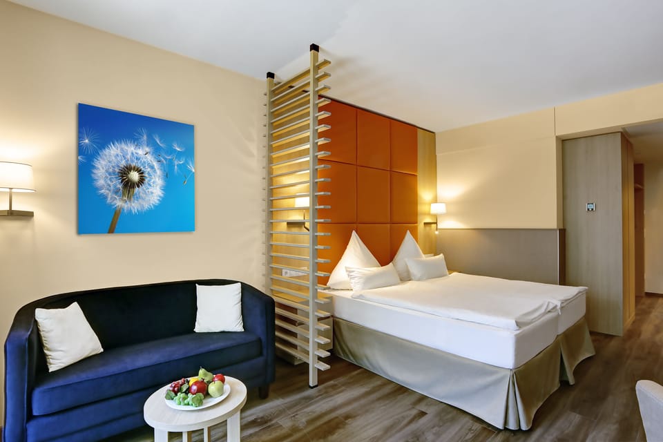 Deluxe Double Room | Living area | Flat-screen TV, books