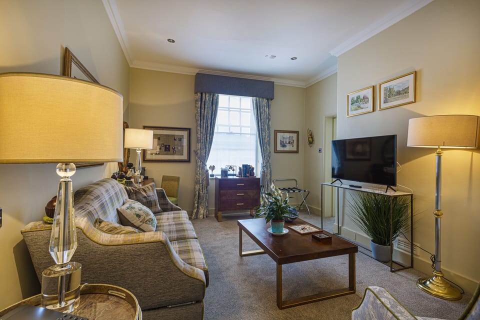 Deluxe Suite | Living area | 40-inch flat-screen TV with digital channels