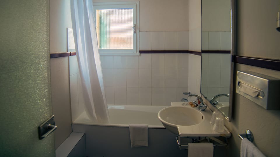 Bathtub, hair dryer, bathrobes, towels