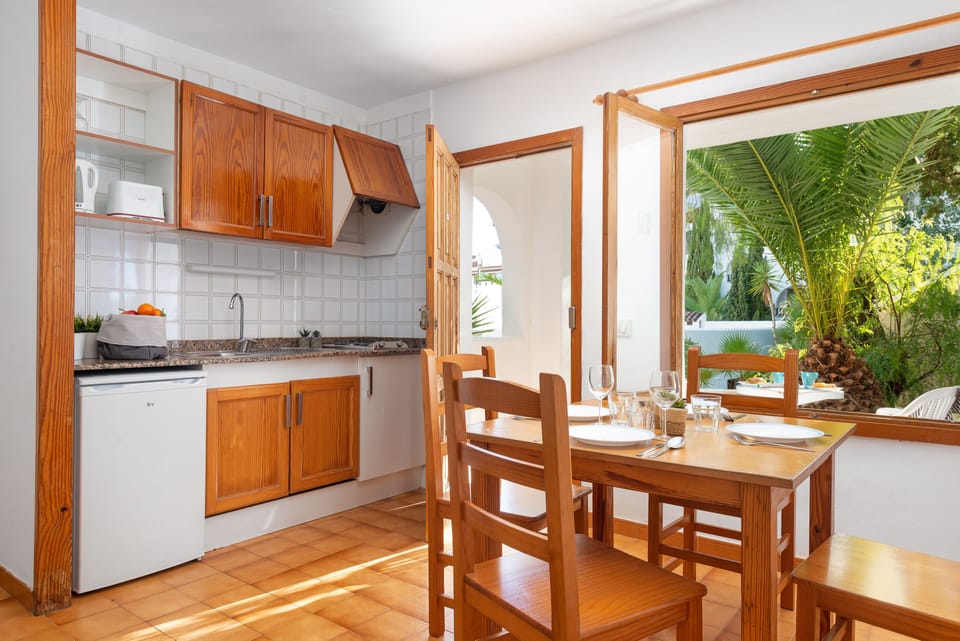 Mini-fridge, toaster, cookware/dishes/utensils, dining table