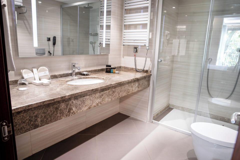 One Bedroom King Suite Room | Bathroom | Rainfall showerhead, hair dryer, slippers, towels