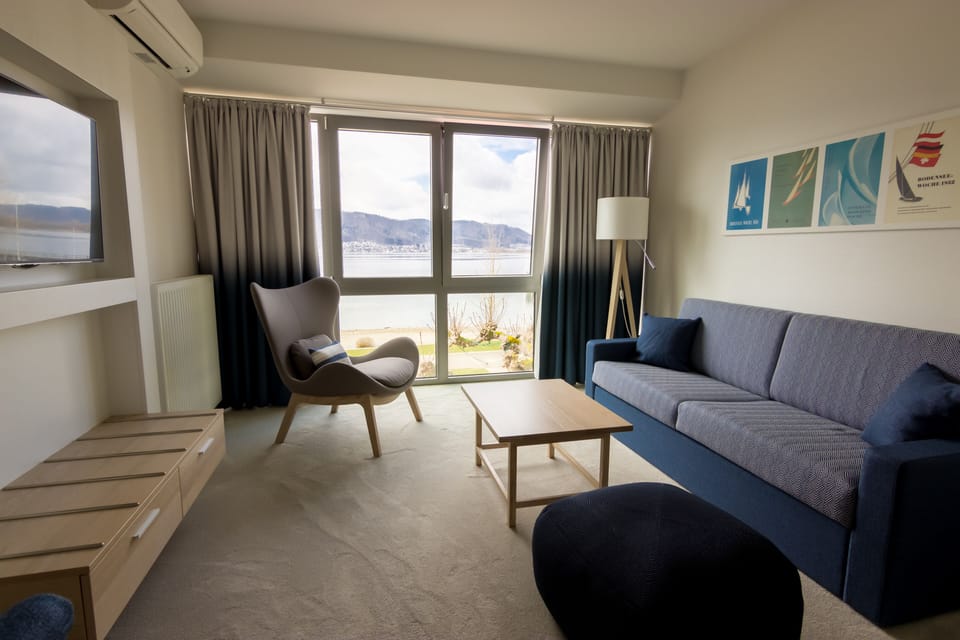 Junior Suite, Lake View (Panoramaverglasung) | Living area | 50-cm flat-screen TV with satellite channels, TV