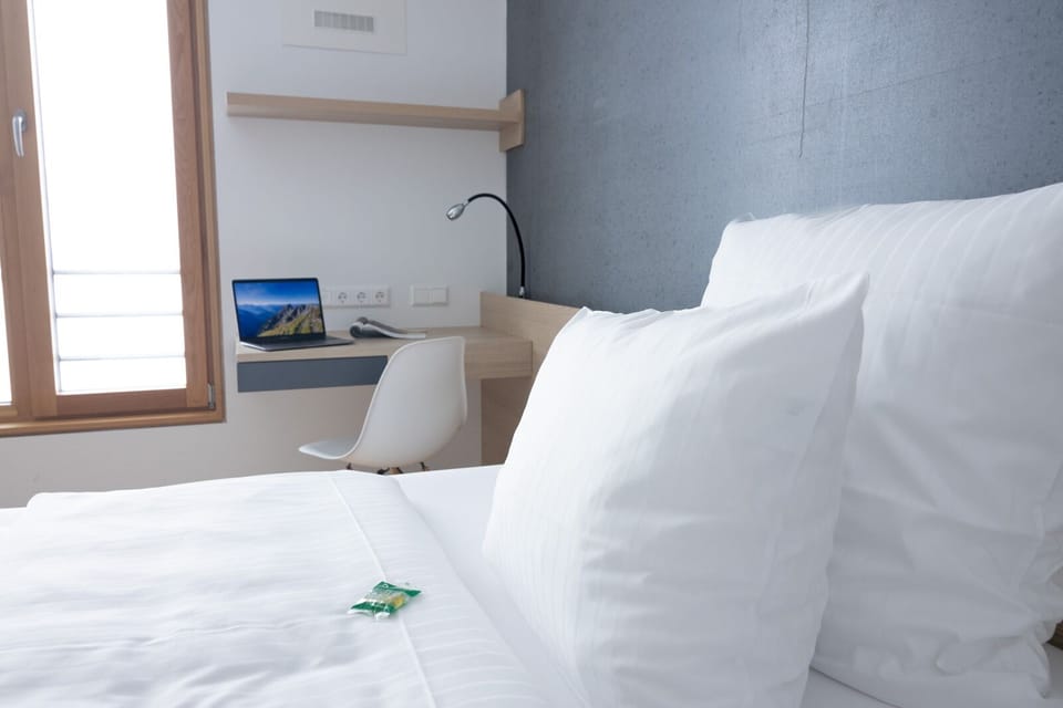 Hypo-allergenic bedding, desk, laptop workspace, blackout drapes
