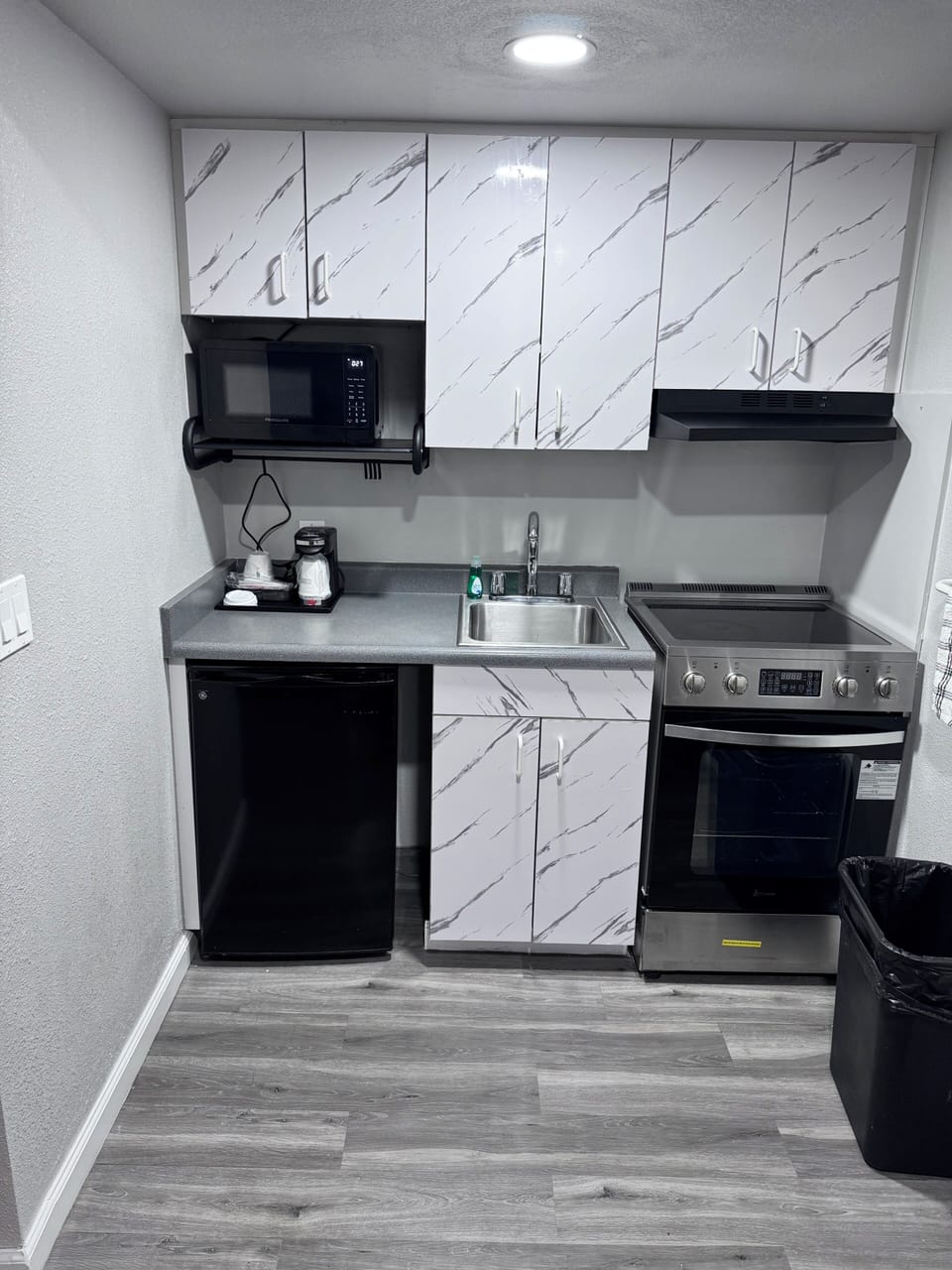 Coffee/tea maker, fridge, microwave, dining table