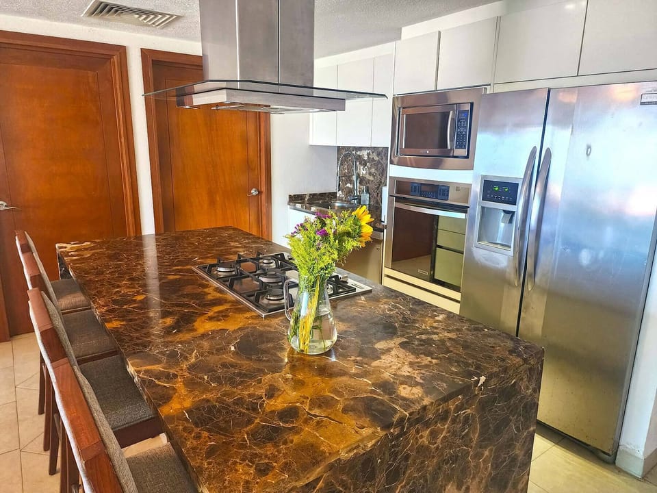 Deluxe Condo | Private kitchen | Full-size fridge, microwave, oven, blender