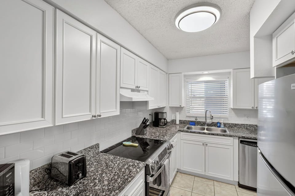 Deluxe Condo | Private kitchen | Coffee/tea maker, full-size fridge, microwave, oven