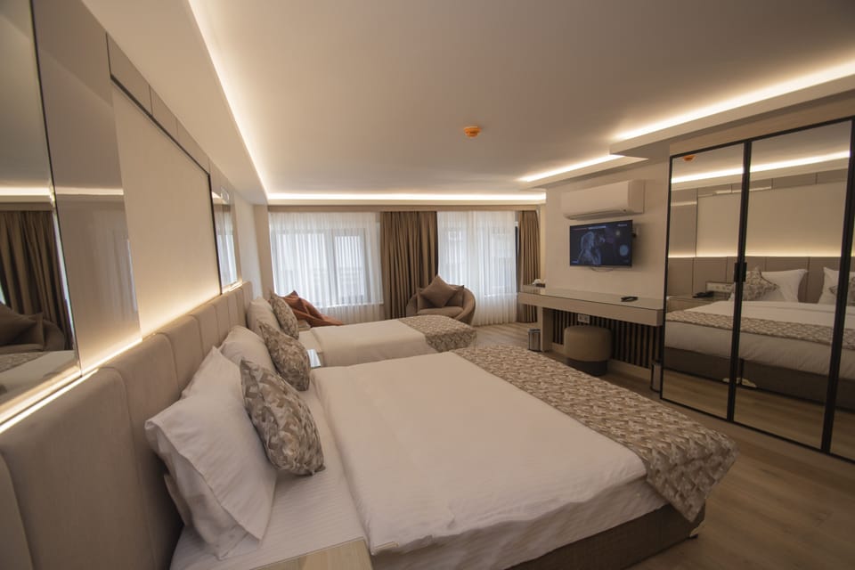 Deluxe Triple Room | Minibar, in-room safe, desk, laptop workspace