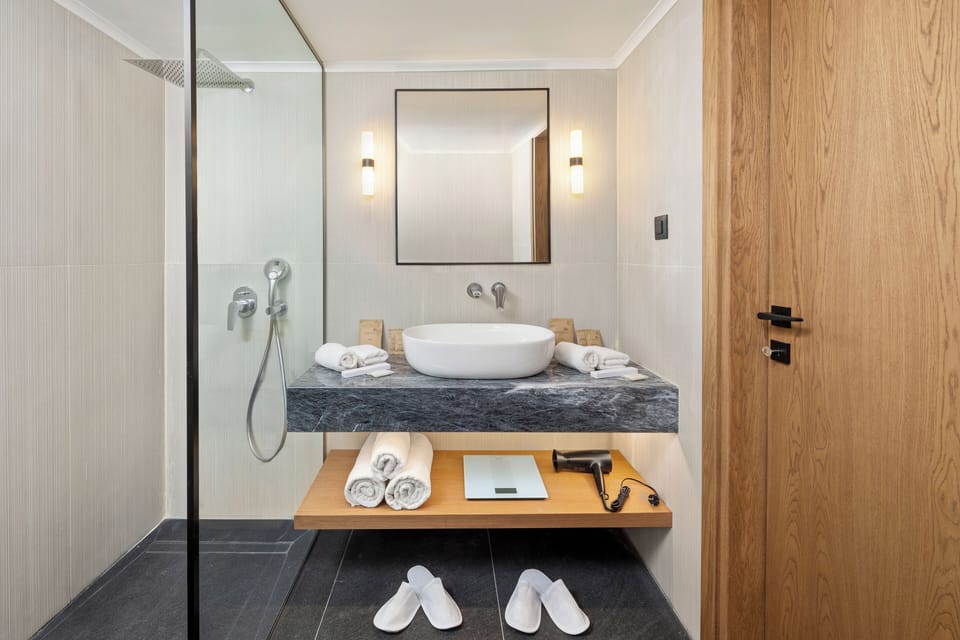 Designer toiletries, hair dryer, slippers, towels