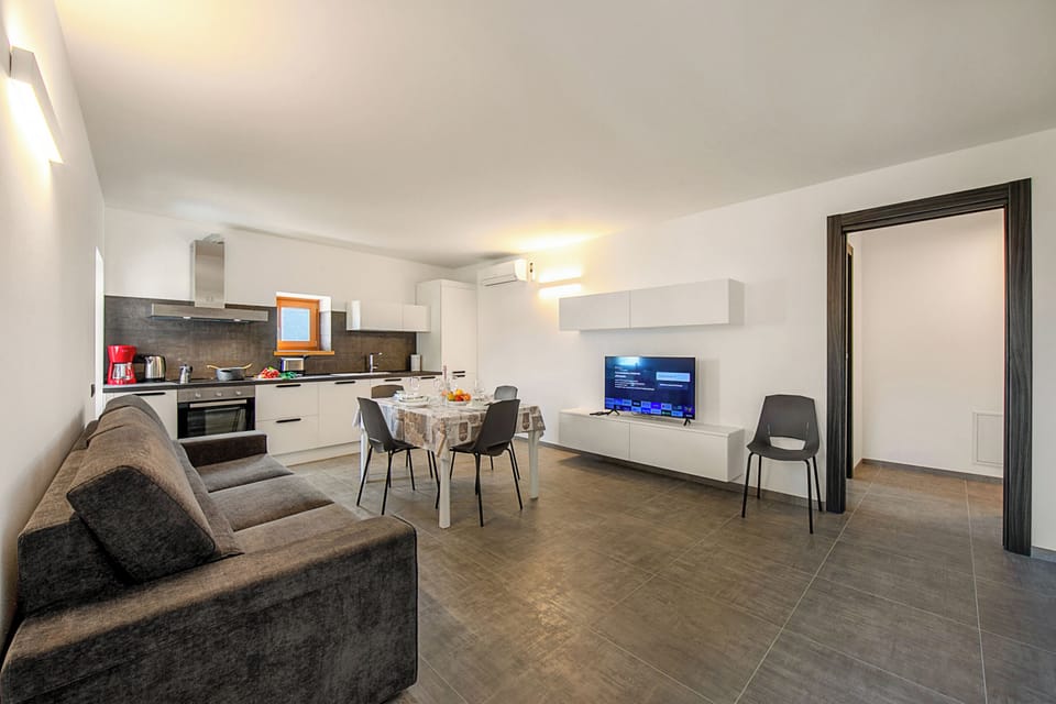Family Apartment, Multiple Bedrooms (Appartamento Borgo Pastoedo) | Living area | 21-inch TV with cable channels