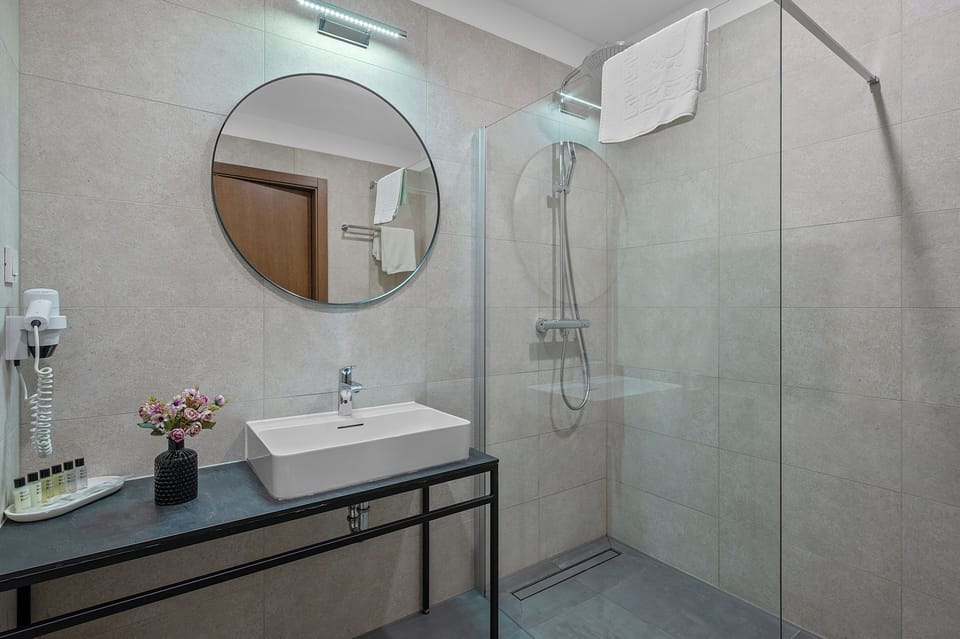 Deluxe Suite, 2 Bedrooms | Bathroom | Shower, rainfall showerhead, hair dryer, slippers