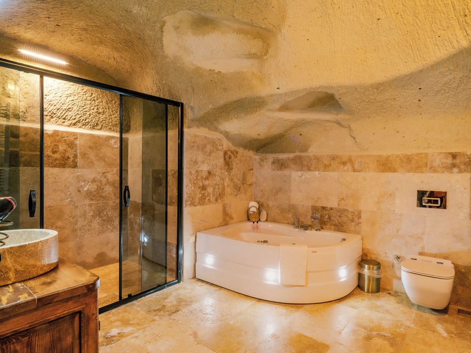 Nimet Deluxe Jacuzzi Cave Suite | Bathroom | Designer toiletries, hair dryer, slippers, towels