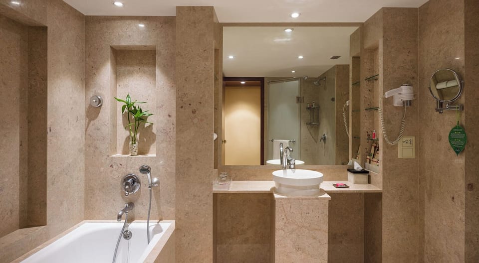 The Lalit Premier Room King Bed | Bathroom | Separate tub and shower, deep soaking tub, rainfall showerhead