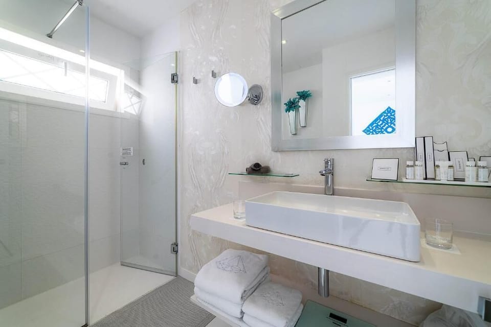 Shower, designer toiletries, hair dryer, bathrobes