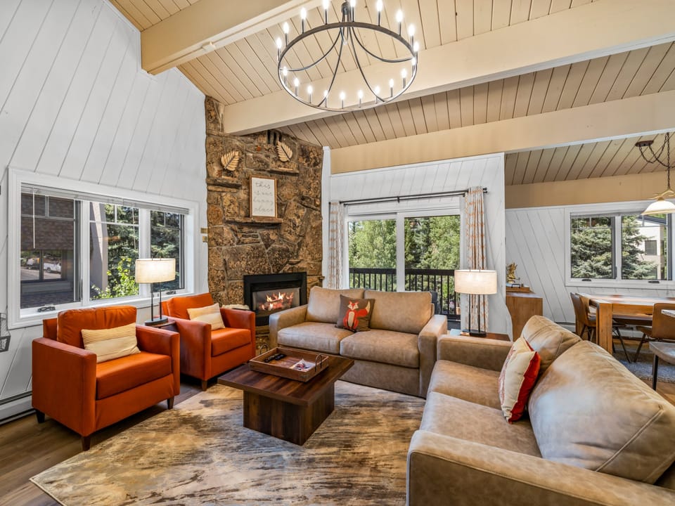 Unwind in your spacious living room, where a crackling fireplace, vaulted wood ceilings, and mountain views create the perfect alpine retreat for relaxation.