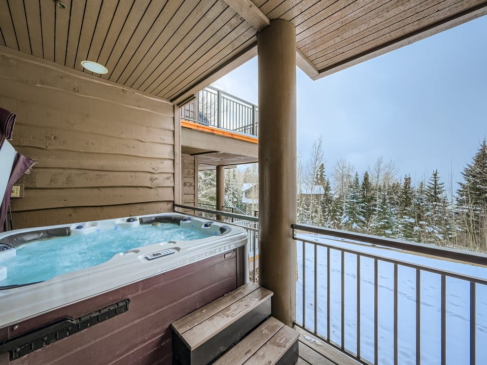 Soak in your private hot tub while enjoying snowy forest views from your covered balcony - the perfect alpine retreat after a day of winter adventures.