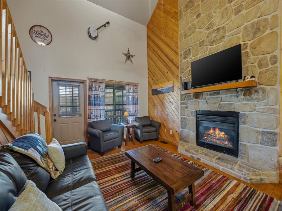 Cozy up by the stone fireplace in your spacious living room with rustic wood accents and comfortable leather seating.