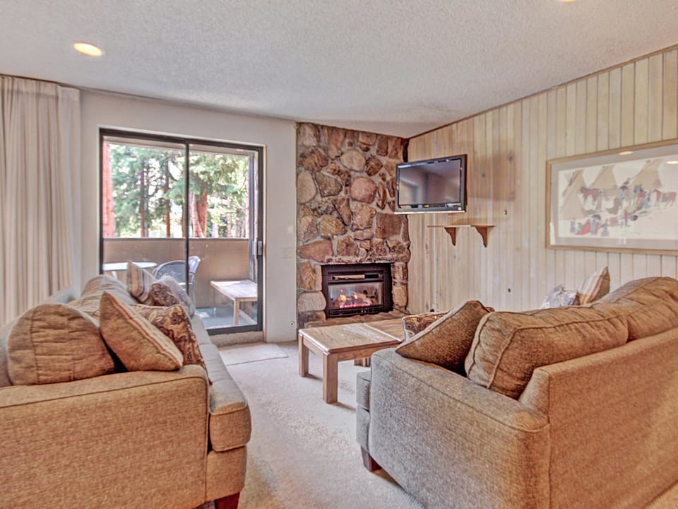 Relax in the cozy living room which offers a fireplace, TV, and cozy seating.