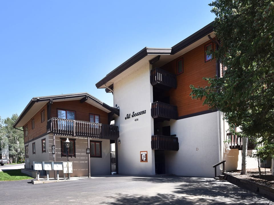 All Seasons property features alpine-style architecture with multiple balconies and convenient ground-level access in a peaceful neighborhood setting.