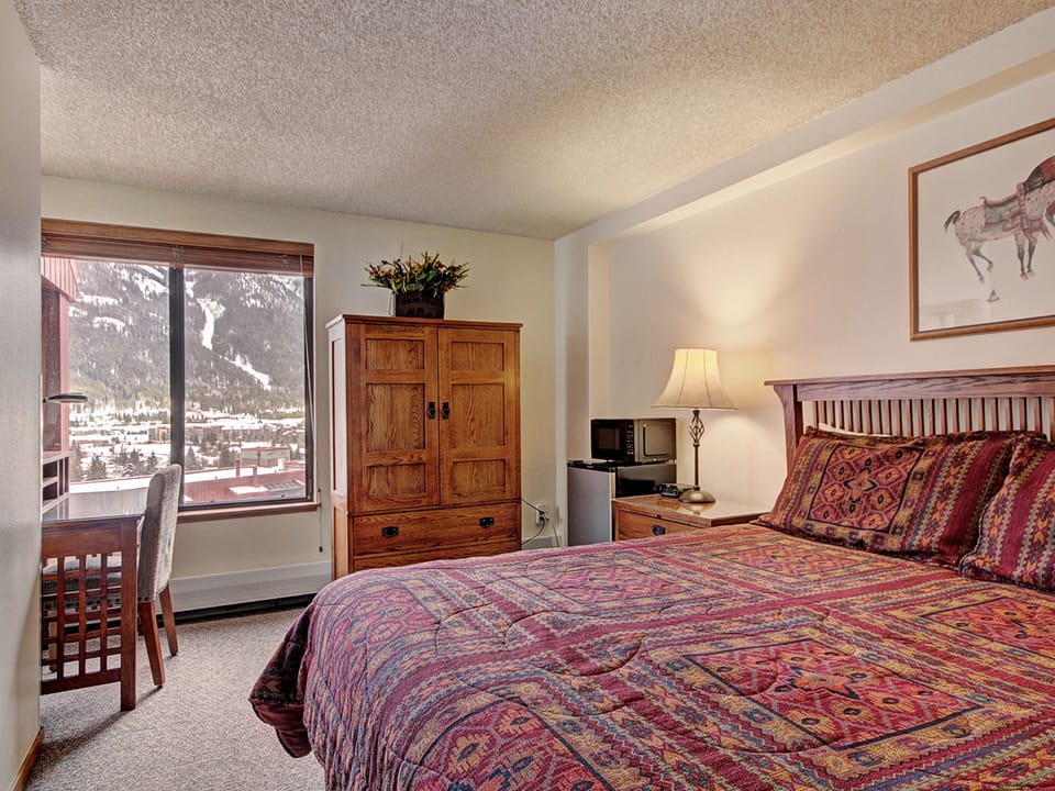 Cozy hotel room features a king bed