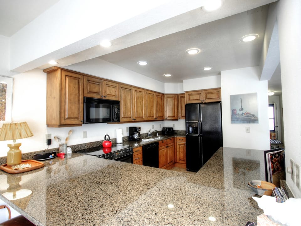 The kitchen has gorgeous granite counter-tops and wood cabinets.