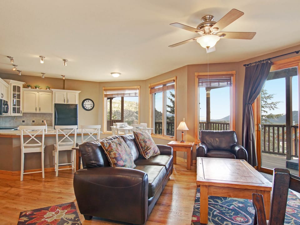 Sheep Mountain 20B - Living room with leather sofa and chair opens into kitchen with seating at the breakfast bar.