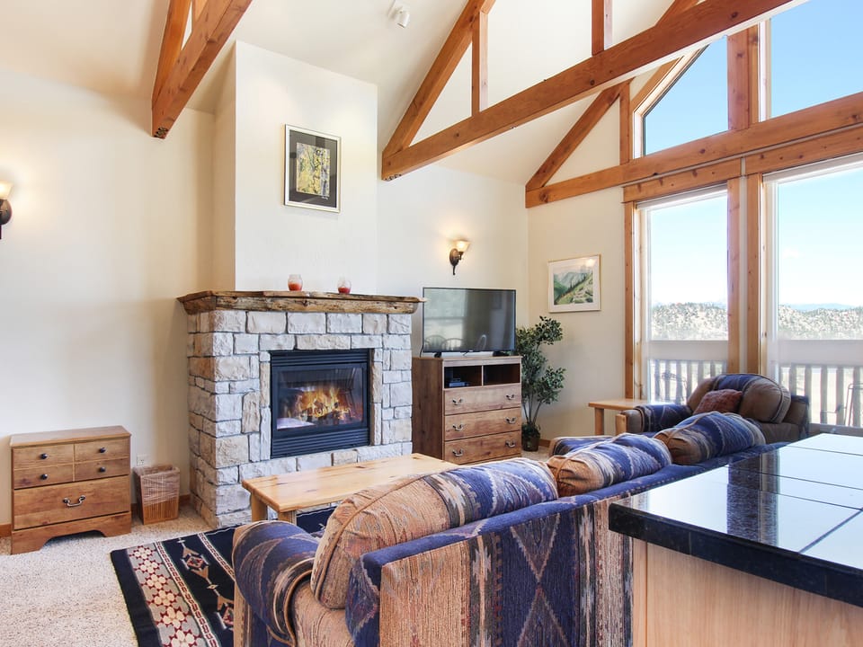 Comanche Peak 39 - Flat-screen TV and gorgeous stone fireplace in the main living area, floor to ceiling windows offer beautiful mountain views.