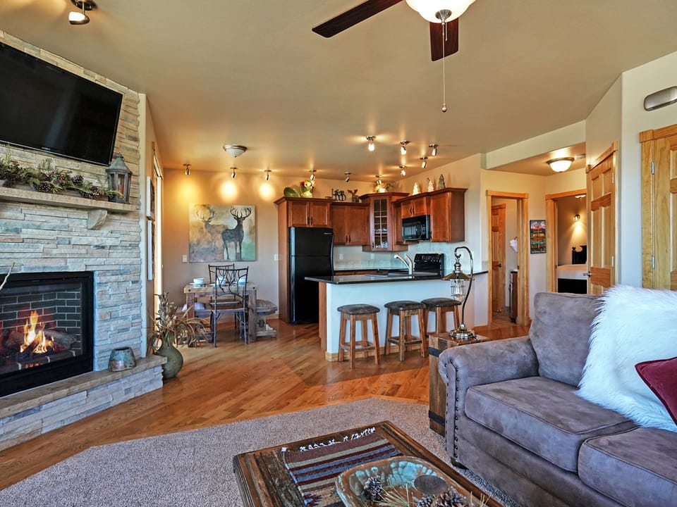 Bighorn Mountain 19B - Open concept living room/kitchen with gas fireplace, queen sleeper sofa, breakfast bar with seating and dining table that seats six.