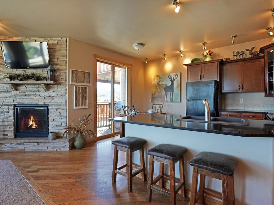 Bighorn Mountain 19B - Kitchen area has breakfast bar with seating. Opens to living room with fireplace and flat screen TV