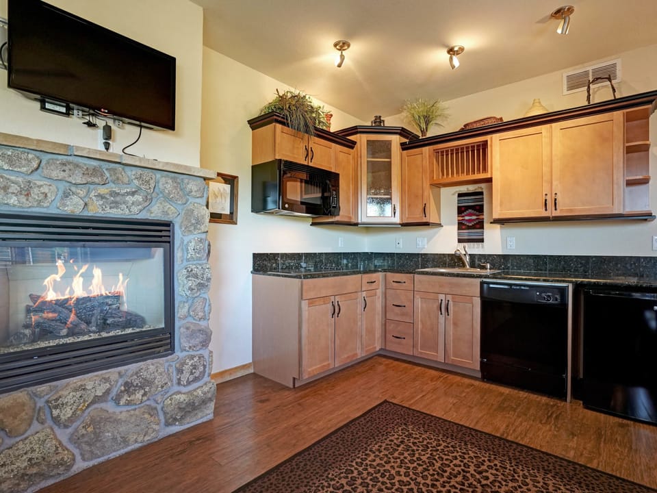 Mount Meeker 26B - Efficiency kitchen with stove top (no oven), microwave, and compact refrigerator, open to living/dining area.