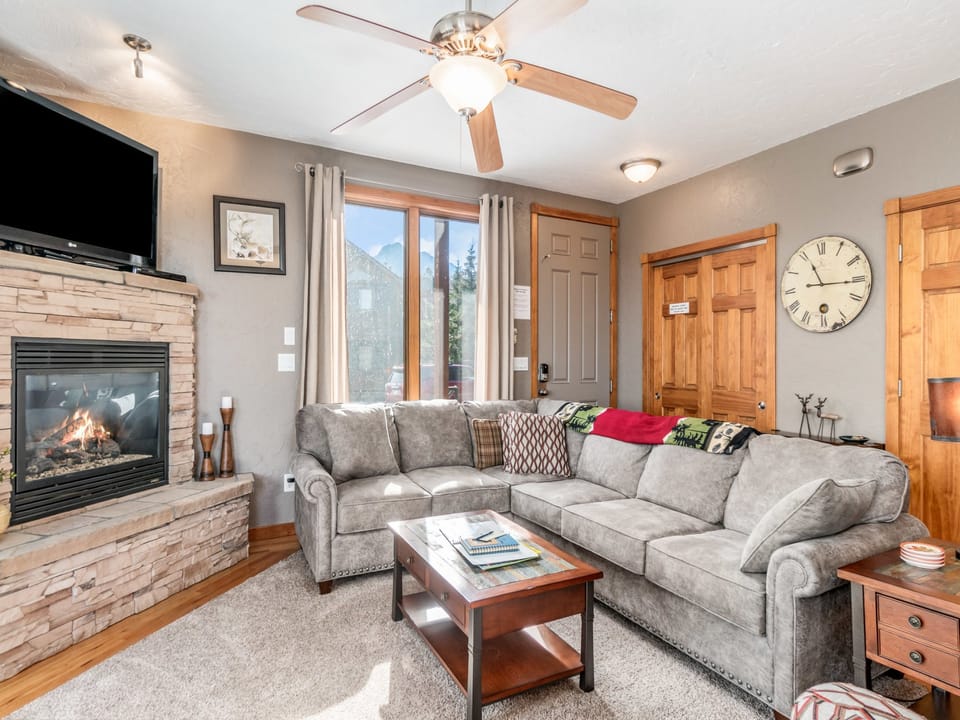 Mount Cirrus 10B - The living room offers a comfortable L shaped sofa with queen sleeper right inside the front door. Snuggle up and enjoy the mountain views, the gas fireplace and flat screen TV.