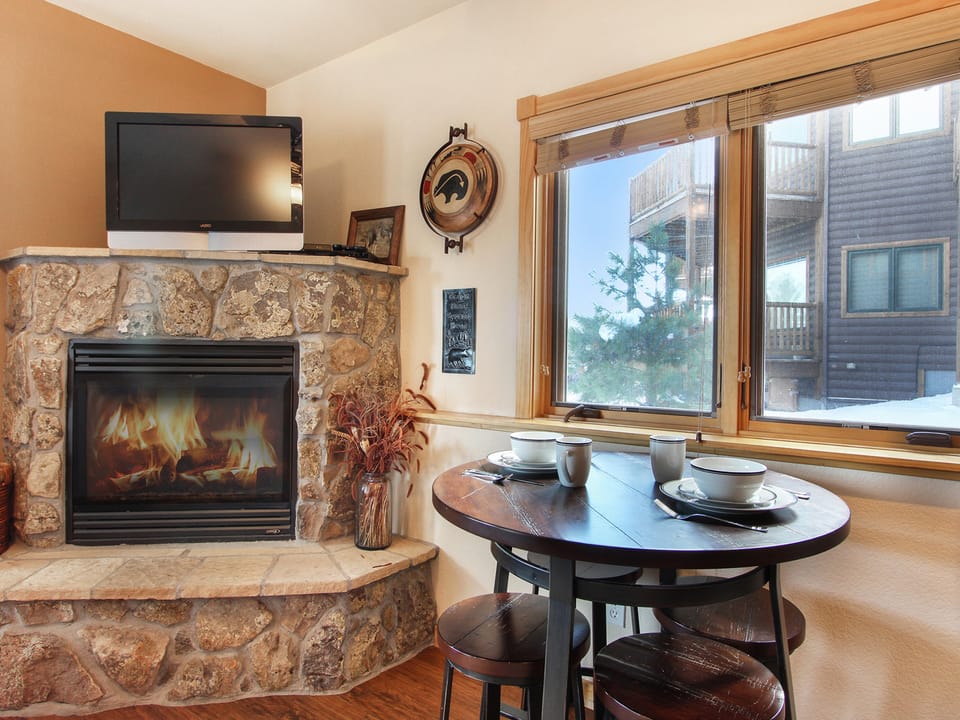 Lookout Mountain 27B - Bar height table with seating for four adjacent to stone fireplace.