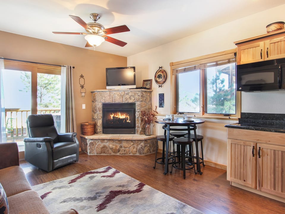 Lookout Mountain 27B - Open living/dining area with stone gas fireplace, bar height table with seating for four, lazy boy recliner and queen sleeper sofa.
