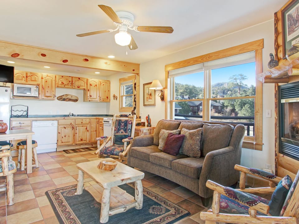 Ptarmigan Mountain 202 - Three cushion sofa in the main living area, beautifully rustic log furniture, rocking chair, lovely stone gas fireplace.