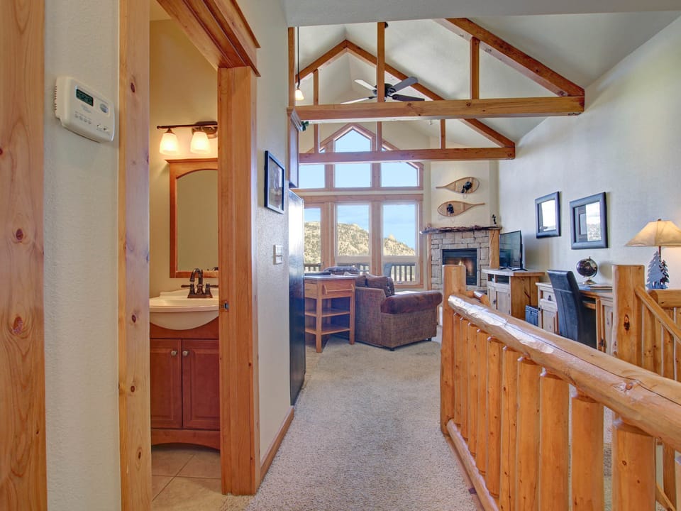 Nisa Mountain 36 - Vaulted ceilings, large floor to ceiling windows with breathtaking mountain views in main entry way, main level bathroom adjacent to the stairway down to the lower level with beautiful log railing.