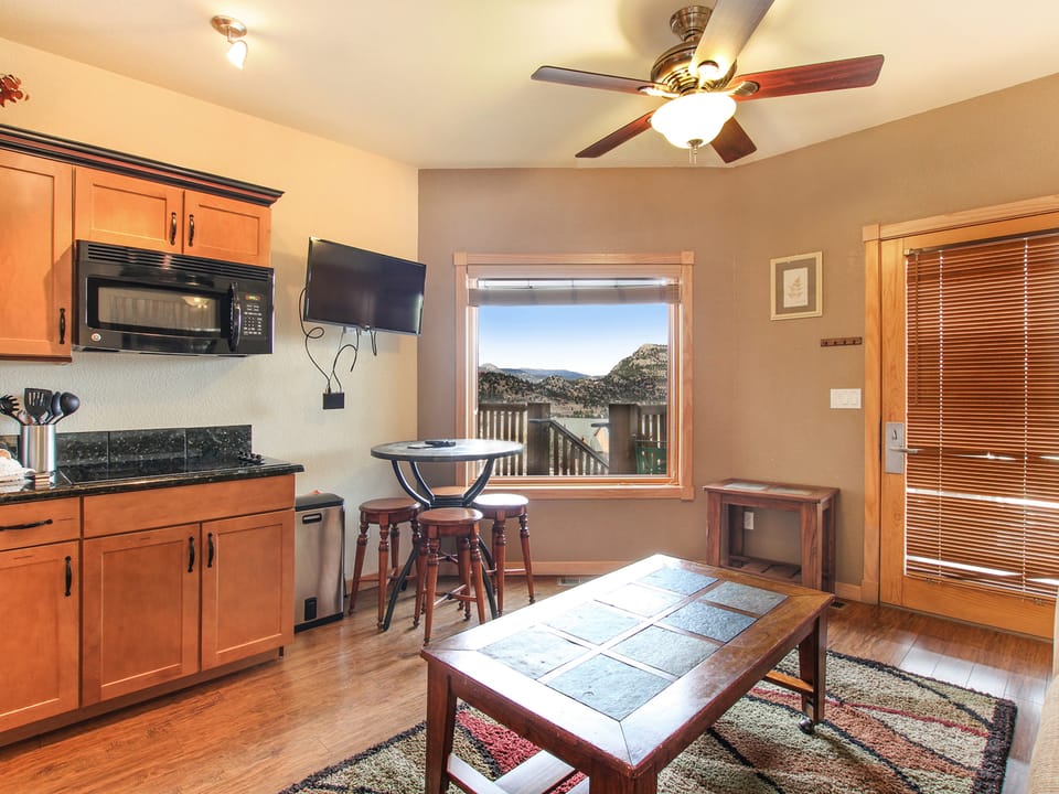 MacGregor Mountain 27C - Window in the cozy combo kitchen/dining area opens up to breathtaking mountain views to be enjoyed from the bar-height dining table with seating for four.