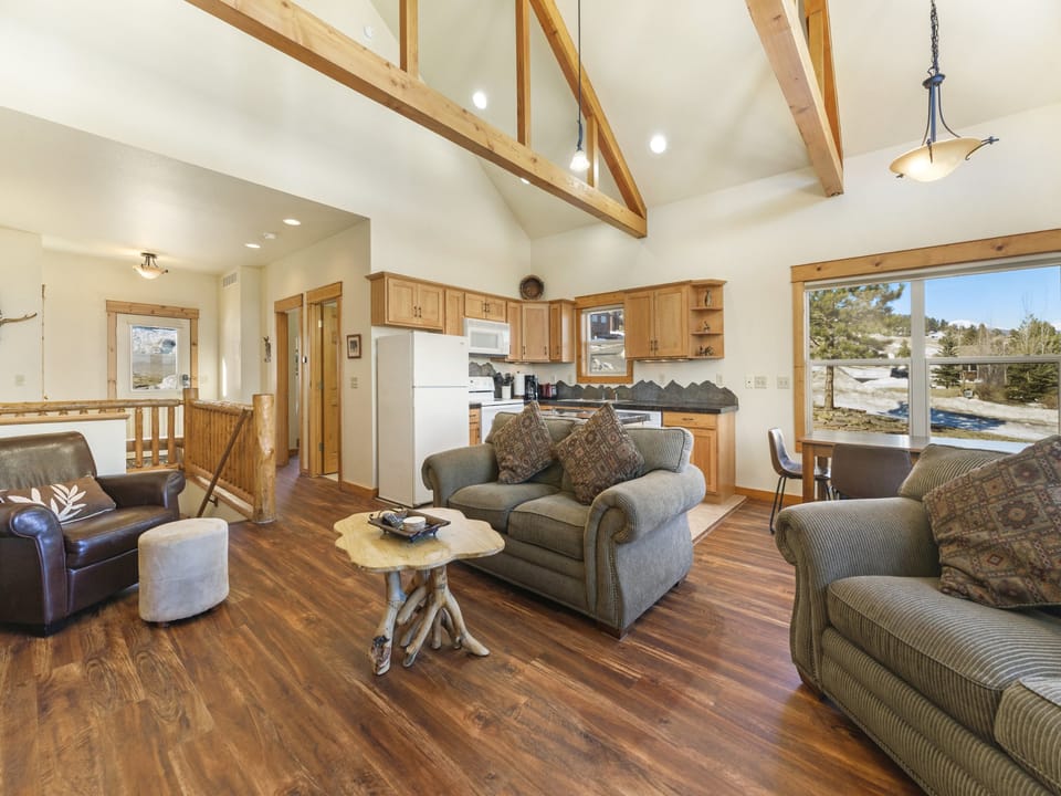 Jackstraw Mountain 32 - Main level living area with two double-cushion sofas, a loveseat, and vaulted ceilings. Beautiful mountain views from large floor to ceiling windows.