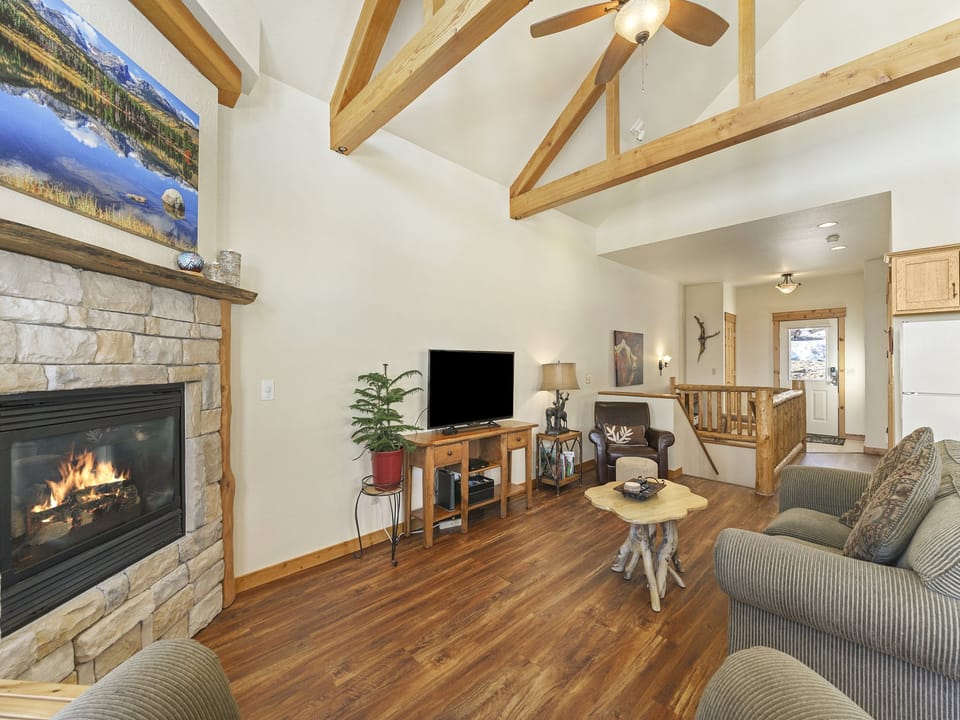 Jackstraw Mountain 32 - Gorgeous stone fireplace, flat screen TV, and two double-cushion sofas in main living area, opens up to the kitchen/dining area.