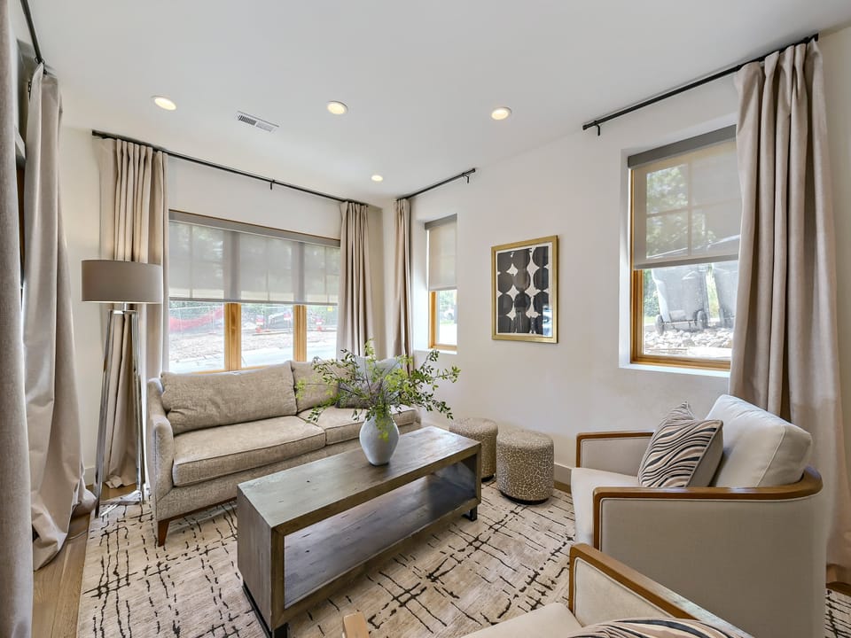 Unwind in your bright, naturally-lit living space with plush seating, modern furnishings, and soft neutral tones that create a calm, welcoming retreat.