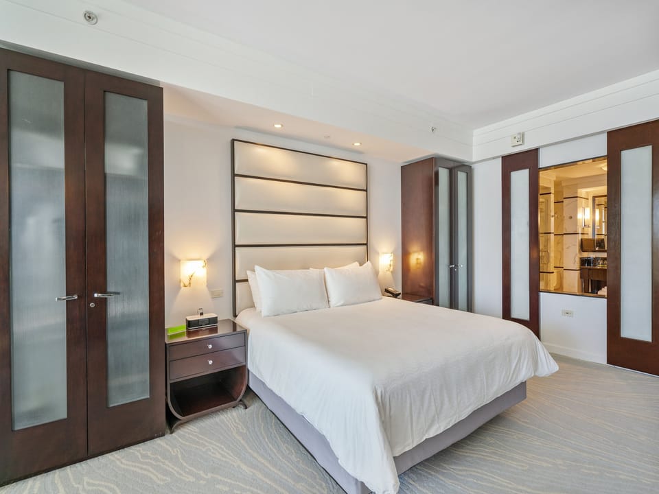 King bed featuring goose-down pillows and luxurious linen. The best sleep you'll ever have.