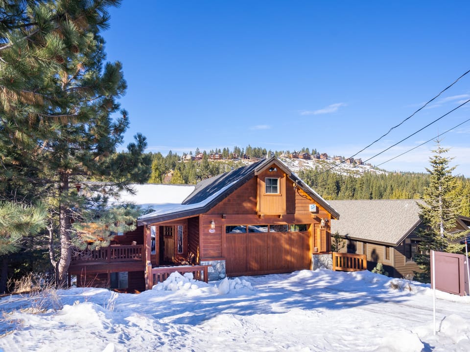 Charming street view of the home with ample parking, a cozy front covered porch, and stunning Tahoe vistas in the backdrop.
