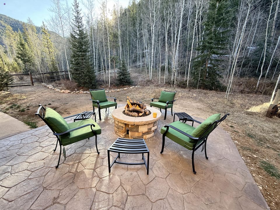 Gather around your private fire pit on comfortable patio seating, surrounded by towering aspen trees and mountain wilderness - the perfect spot for evening conversations under the stars.