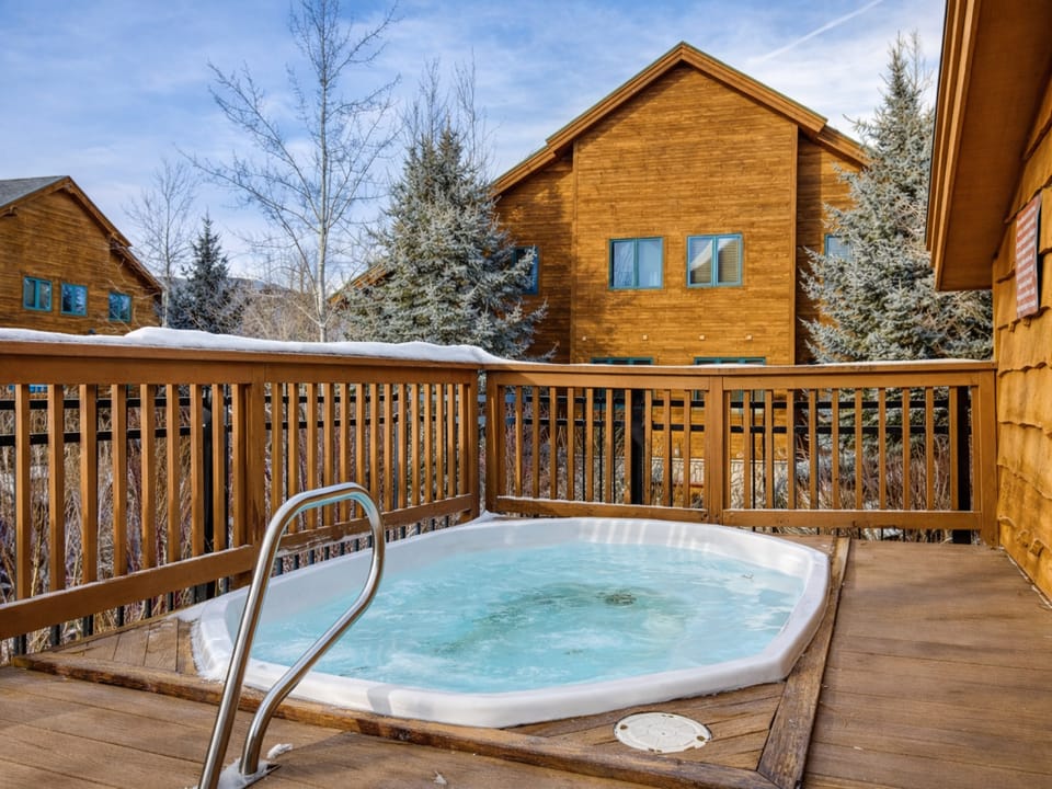 Soak in your private hot tub on this wooden deck, surrounded by snow-dusted pines and cozy alpine chalets.